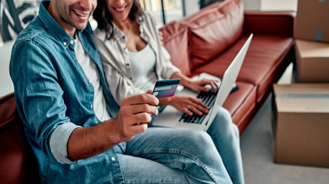 Para siedząca na kanapie podczas pobierania pożyczki online